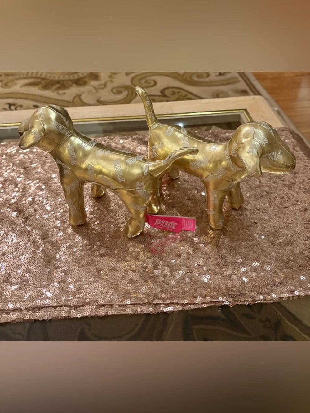 Lot of two 6” high x 10”  Victoria’s Secret gold metallic dogs w/allover logos